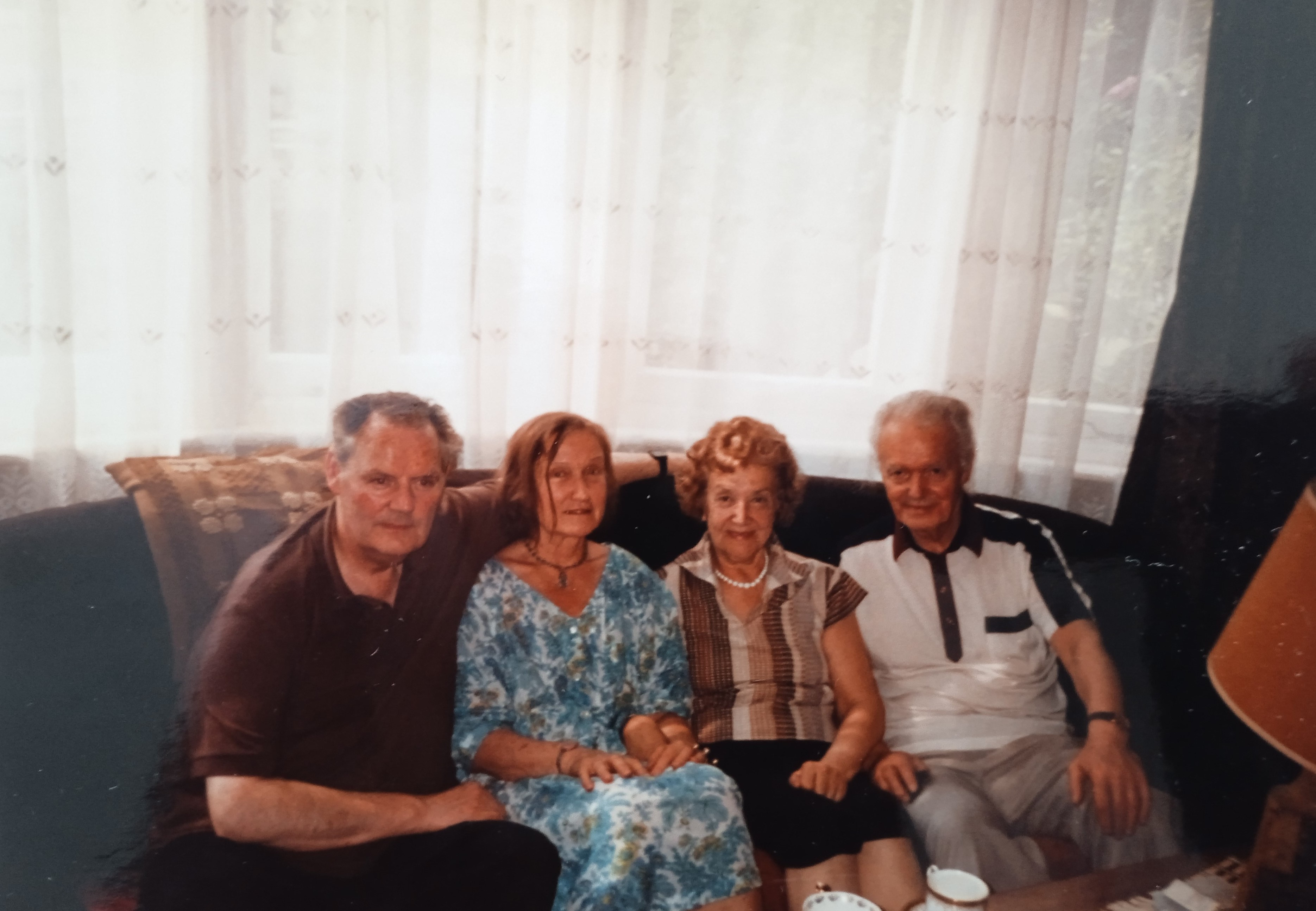 Velta Sniķere ar vīru Džeimsu Vilsonu (James Wilson) pie draugiem operdziedātājas Gaidas Trēziņas – Mazītes un gleznotāja Arnolda Mazīša Londonā 1990. gadā. LNA_LVA, F2709_1v_3, 1. lp.