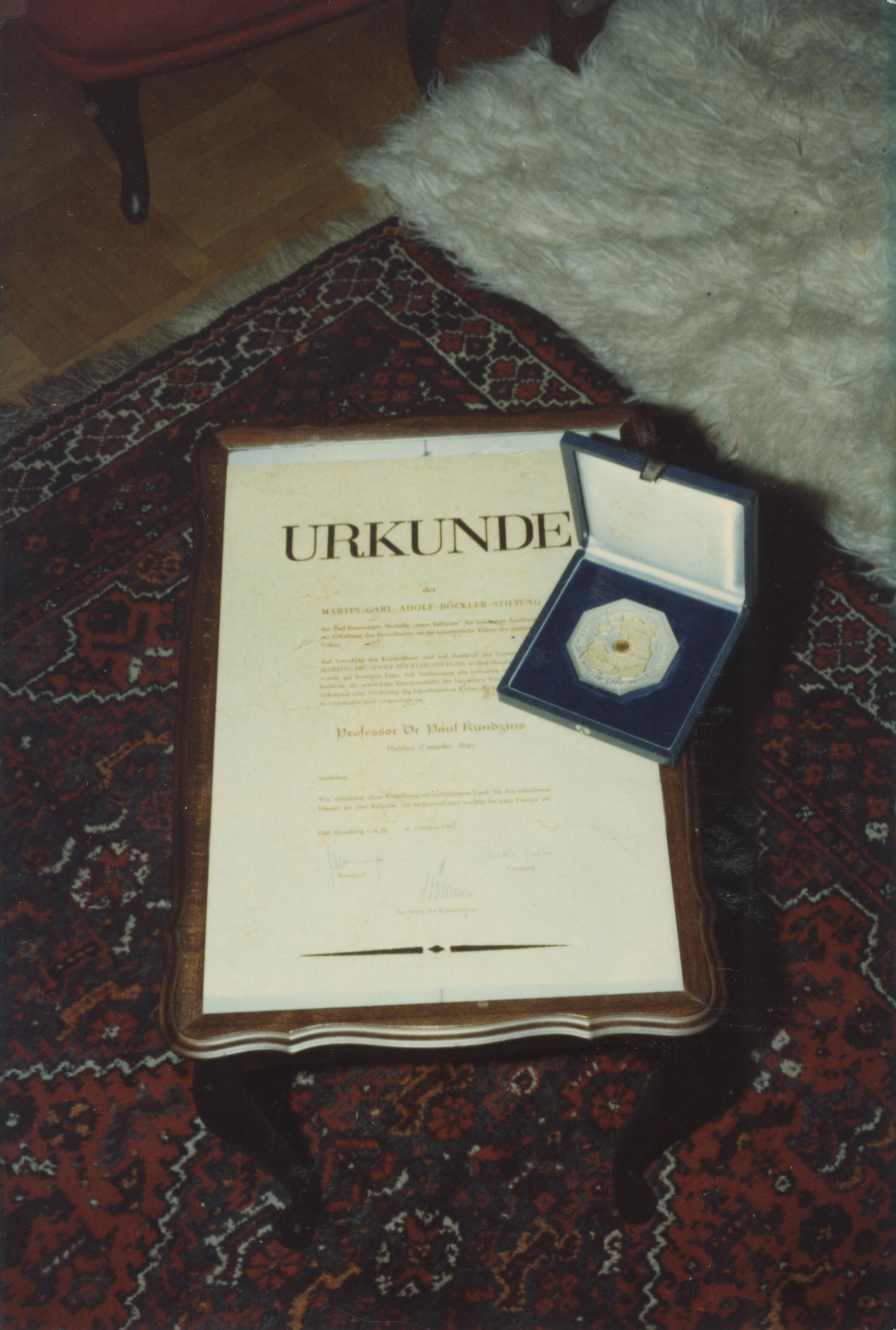 P. Kundziņam pasniegtā Martina Karla Ādolfa Bēklera fonda diploma un medaļas fotogrāfija, 20. gadsimta 70. gadi, autors nav zināms. LNA_LVA, F2280_1-v_4, 22. lp.